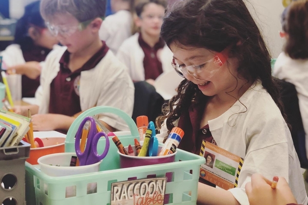 kindergarten girl does science activity in lab coat and eye goggles