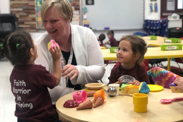 preschool students interact with teacher in classroom